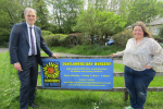 Julian and Heather standing next to the Sunflowers Day Nursery sign